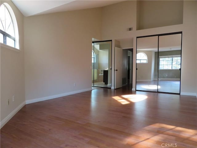 unfurnished room with dark hardwood / wood-style floors and high vaulted ceiling