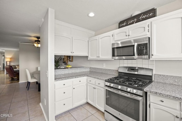 kitchen with white cabinetry, ceiling fan, stainless steel appliances, and light tile patterned floors