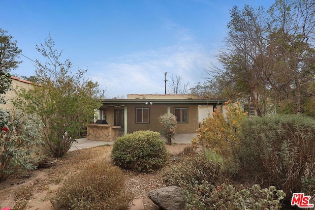 back of house with an outdoor kitchen and a patio area