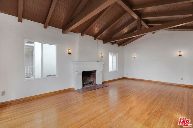 unfurnished living room featuring vaulted ceiling with beams, wood ceiling, and light wood-type flooring