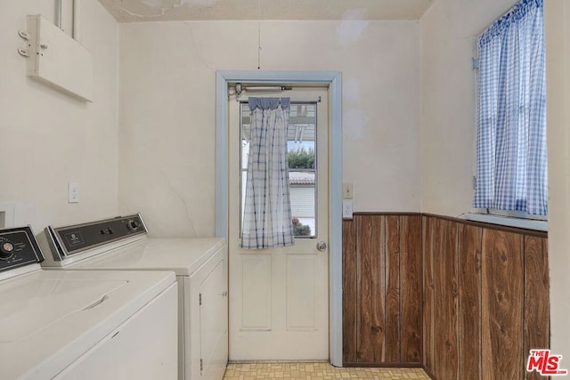 laundry room featuring independent washer and dryer and wood walls