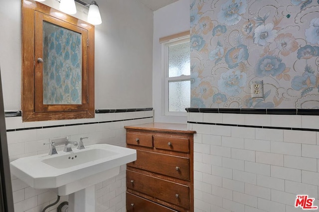 bathroom featuring tile walls and sink