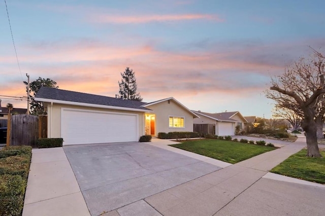 ranch-style home featuring a yard and a garage