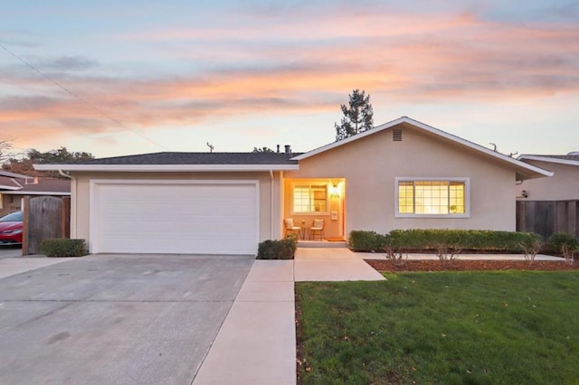 ranch-style house featuring a garage and a lawn