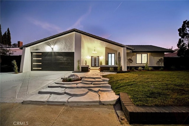 view of front of house with a garage and a yard