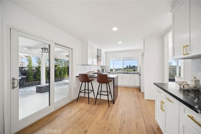 kitchen featuring white cabinetry, a breakfast bar, and backsplash