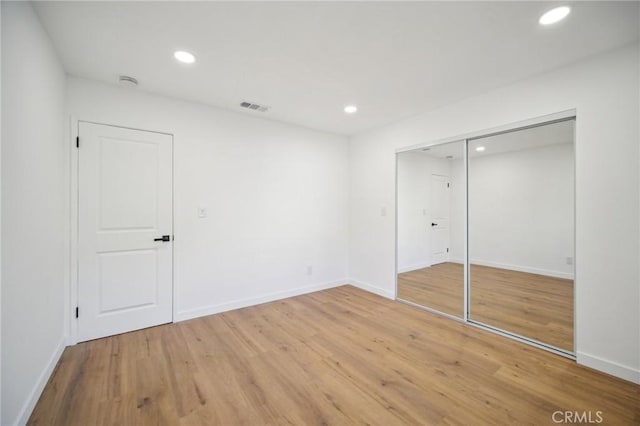 unfurnished bedroom with wood-type flooring and a closet