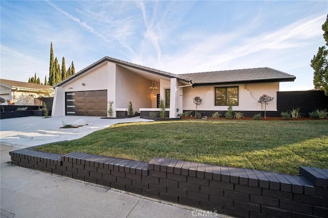 ranch-style home featuring a garage and a front lawn