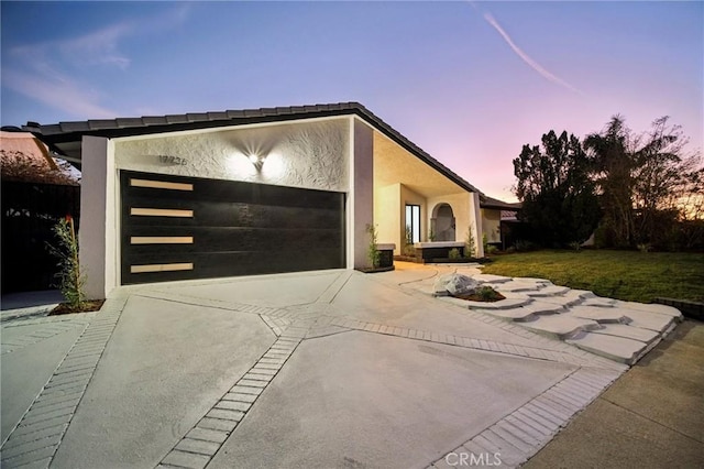 view of front of property featuring a garage and a lawn