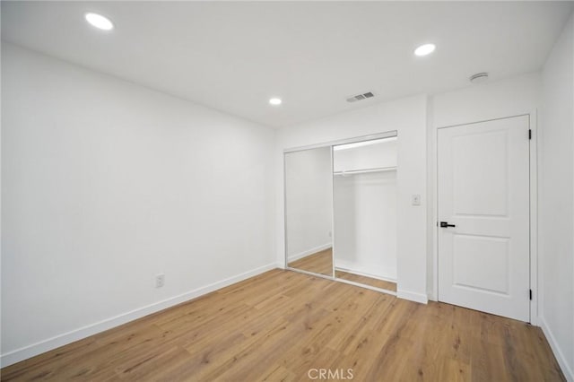 unfurnished bedroom with hardwood / wood-style floors and a closet