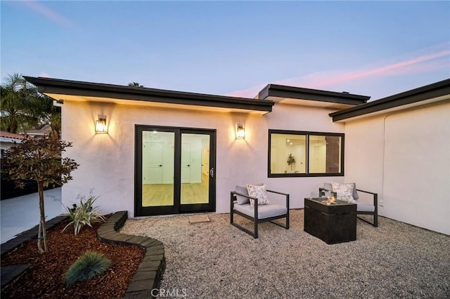 back house at dusk featuring an outdoor fire pit and a patio area