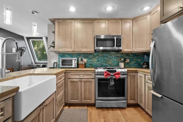 kitchen with sink, decorative backsplash, hanging light fixtures, stainless steel appliances, and light wood-type flooring