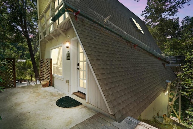 property exterior at dusk with a patio area