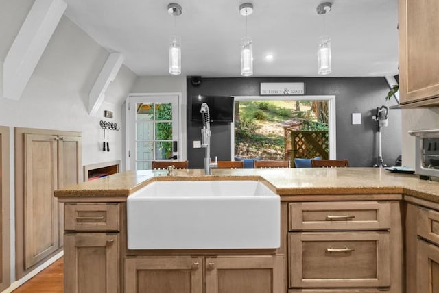 kitchen featuring hanging light fixtures, a healthy amount of sunlight, and sink