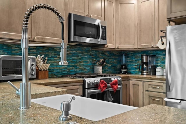 kitchen with stainless steel appliances, light stone countertops, and decorative backsplash