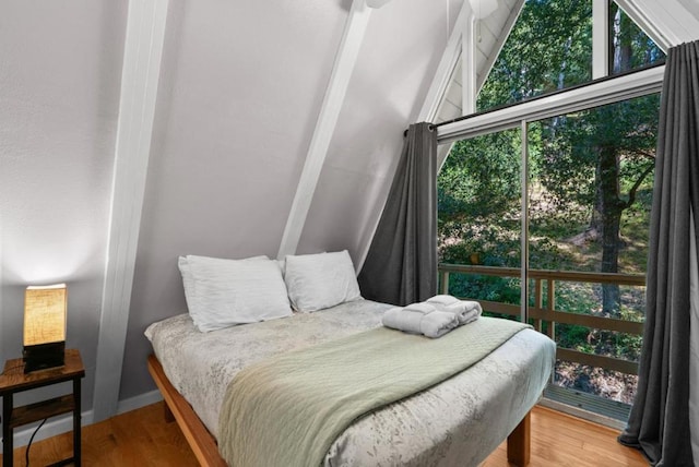 bedroom featuring lofted ceiling and wood-type flooring