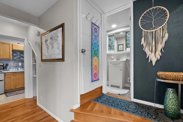 foyer entrance featuring sink and light wood-type flooring