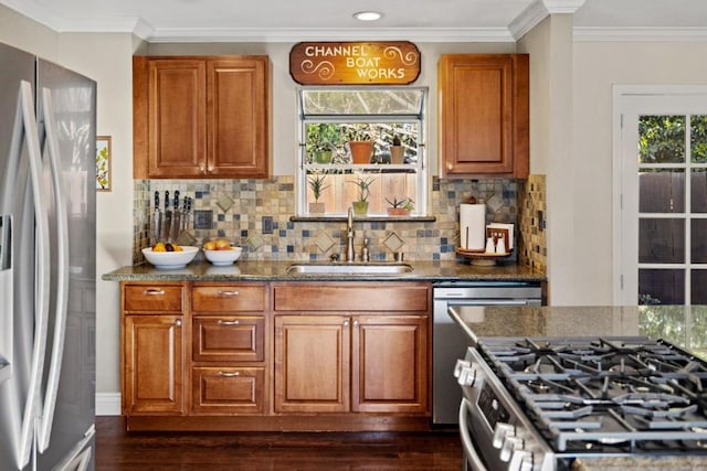 kitchen featuring dark stone countertops, sink, decorative backsplash, and appliances with stainless steel finishes