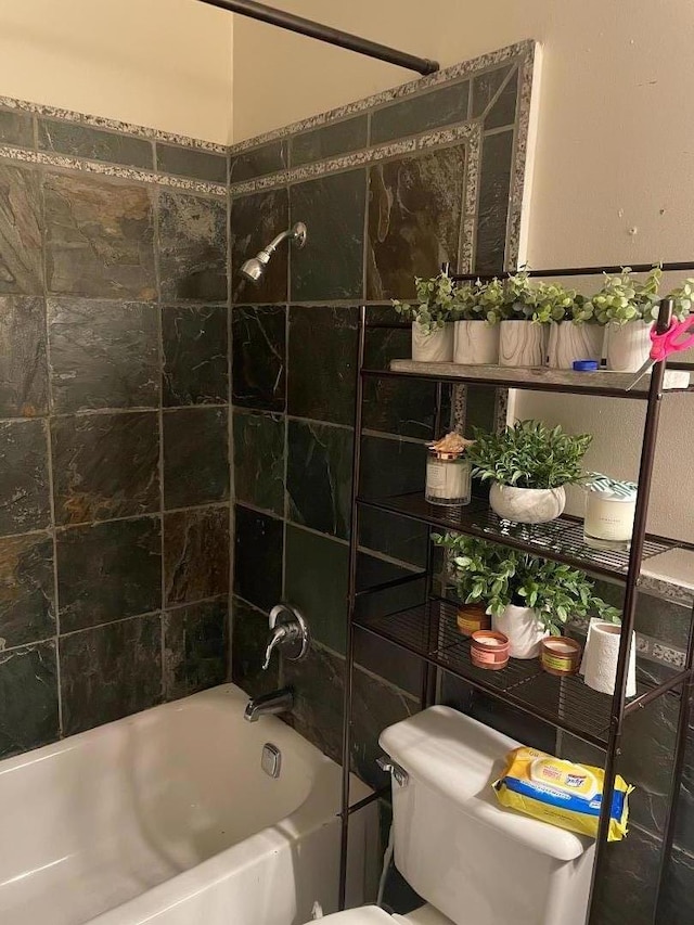 bathroom featuring tiled shower / bath and toilet