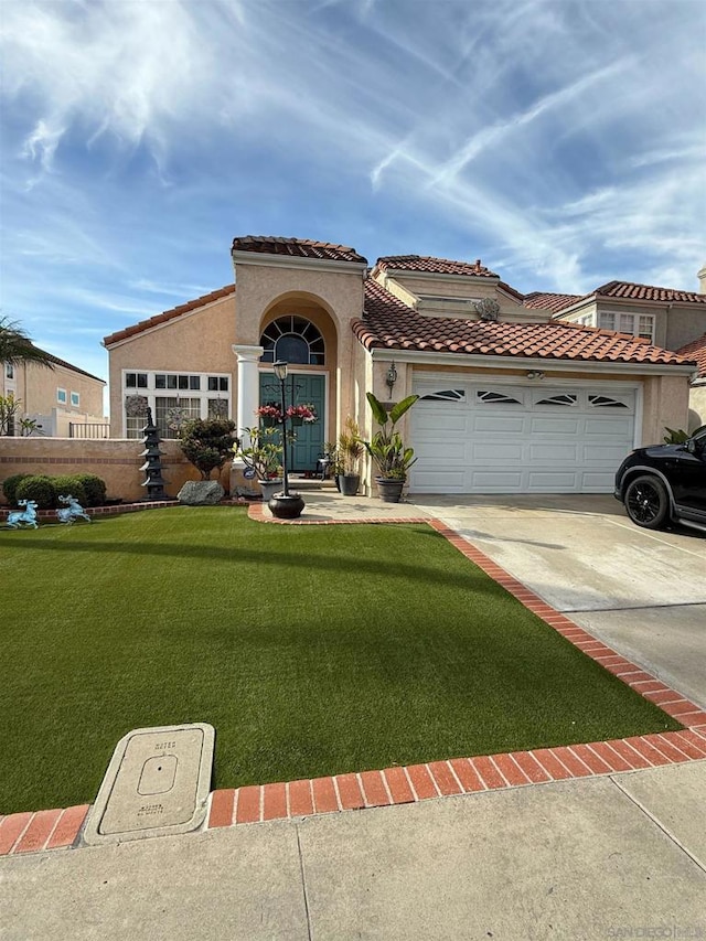 mediterranean / spanish home with a garage and a front lawn