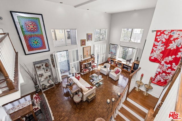 living room featuring dark parquet flooring and a high ceiling