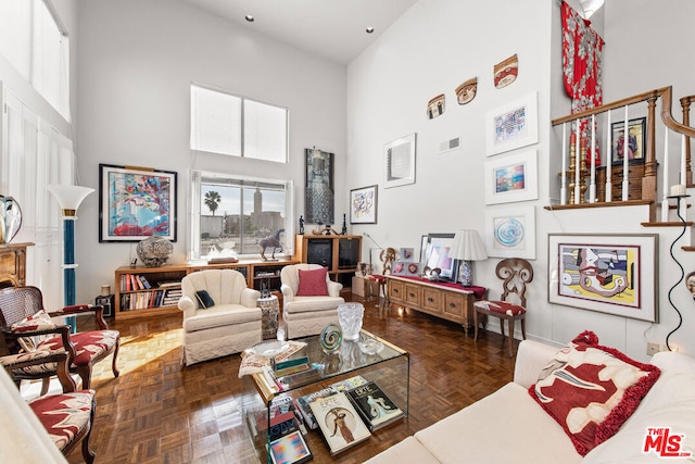 living room with a high ceiling and dark parquet flooring