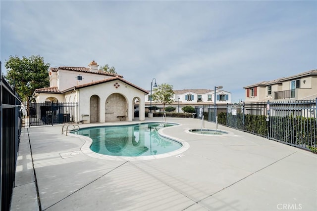 view of swimming pool featuring a community hot tub and a patio area