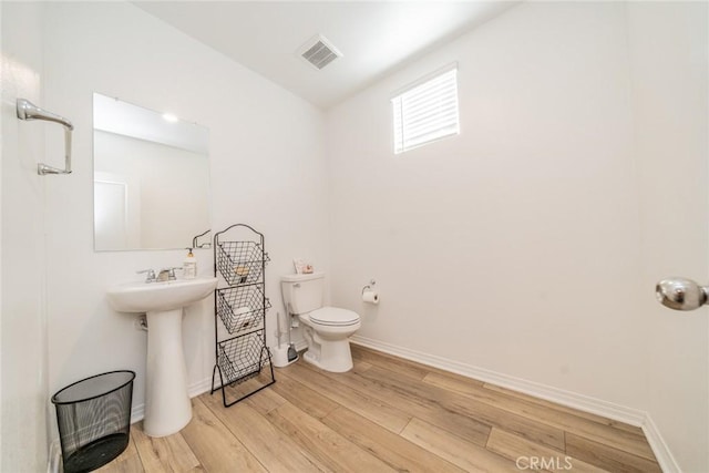 bathroom featuring hardwood / wood-style flooring and toilet