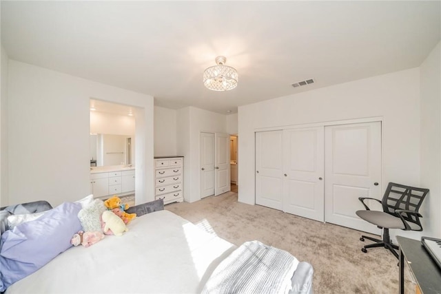 bedroom featuring connected bathroom and light colored carpet