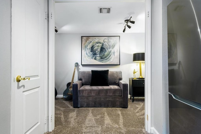 sitting room featuring rail lighting and carpet floors