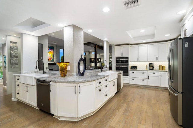 kitchen featuring appliances with stainless steel finishes, sink, and white cabinets