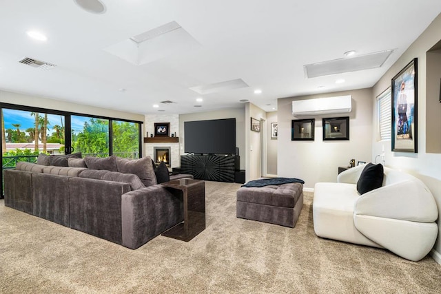 living room featuring light carpet, a wall mounted air conditioner, a fireplace, and a skylight