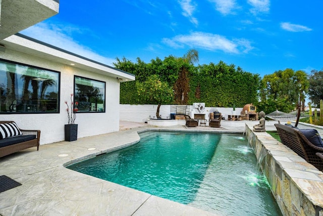 view of swimming pool featuring exterior fireplace, a patio area, and pool water feature