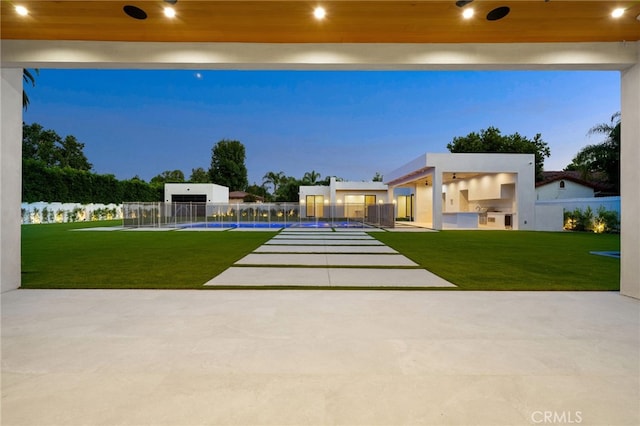 exterior space featuring a pool, a yard, and exterior kitchen