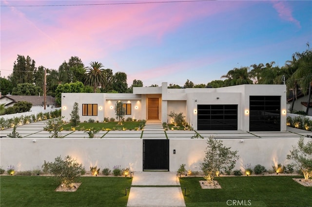 contemporary home with a garage and a lawn