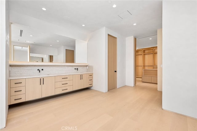 bathroom featuring hardwood / wood-style flooring, vanity, and decorative backsplash