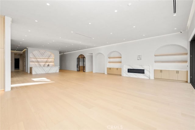 unfurnished living room with a fireplace and light hardwood / wood-style flooring