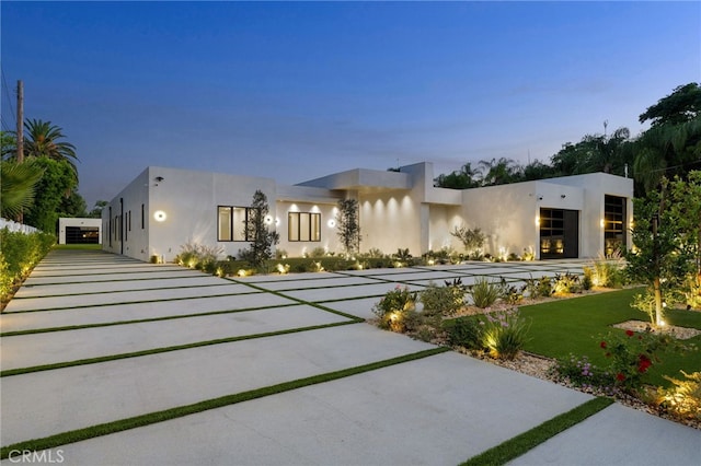 contemporary house featuring a front lawn and stucco siding