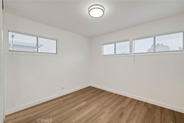 unfurnished room featuring a wealth of natural light and light wood-type flooring