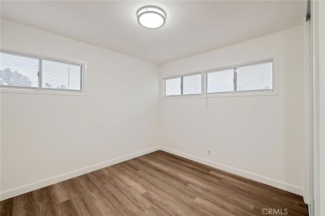 empty room with a healthy amount of sunlight and hardwood / wood-style floors