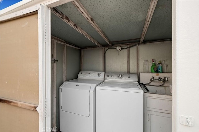 clothes washing area with independent washer and dryer and cabinets