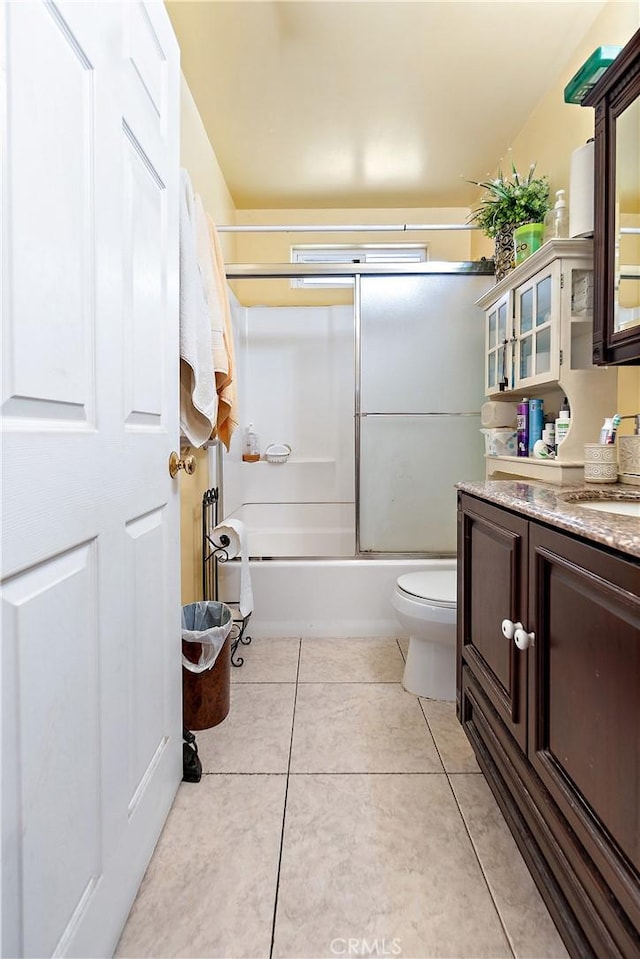 full bathroom with tile patterned flooring, vanity, shower / bath combination with glass door, and toilet