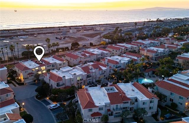 aerial view at dusk with a beach view and a water view