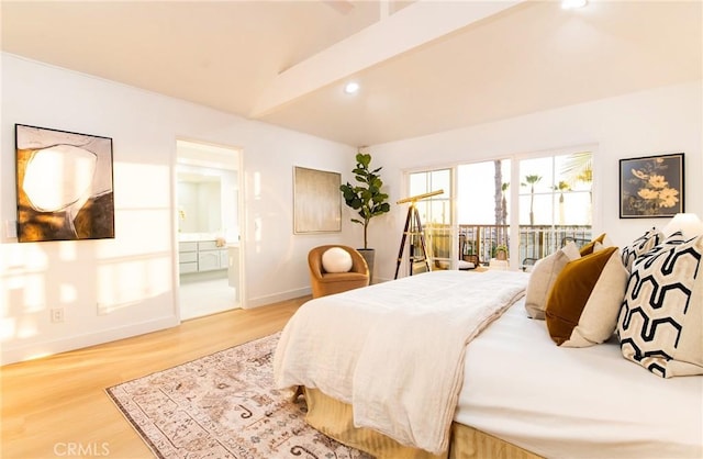 bedroom featuring lofted ceiling, ensuite bath, and wood-type flooring