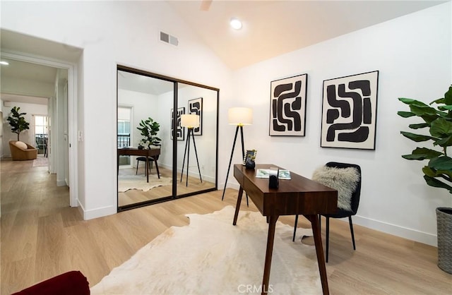 office featuring high vaulted ceiling and light hardwood / wood-style flooring