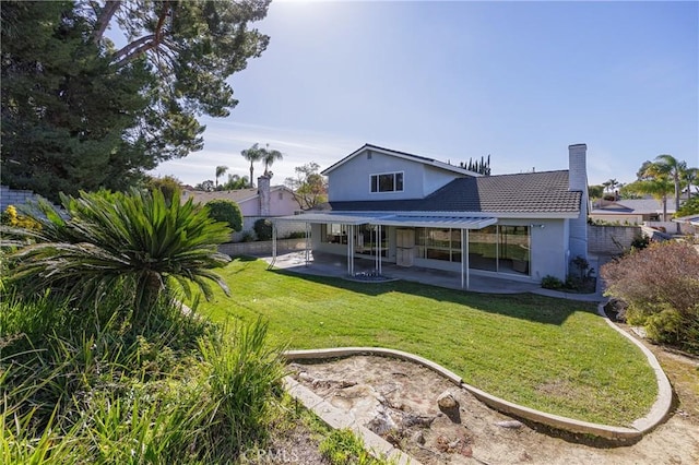 rear view of property with a patio and a lawn