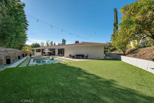 back of house with a patio, an outdoor hangout area, a fenced in pool, and a lawn
