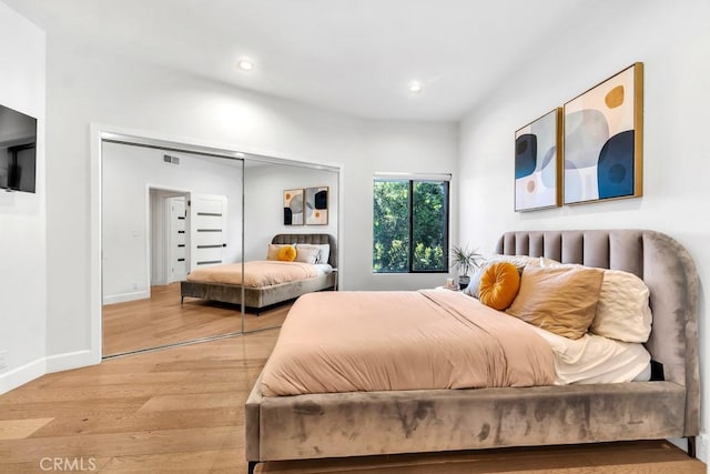 bedroom with light hardwood / wood-style floors and a closet