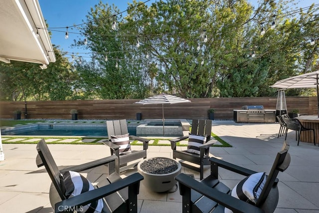 view of patio / terrace featuring an outdoor bar, area for grilling, an outdoor fire pit, and a pool with hot tub