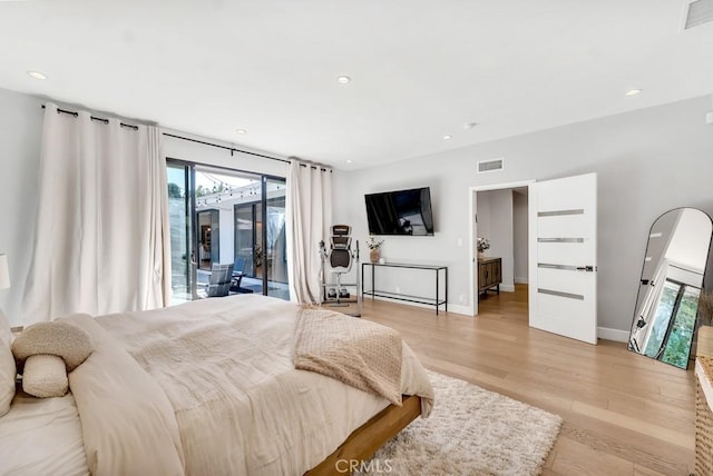 bedroom featuring access to exterior, multiple windows, and light wood-type flooring
